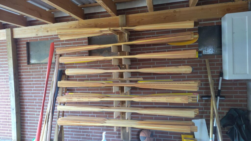 A rack with dozens of greenland-paddles